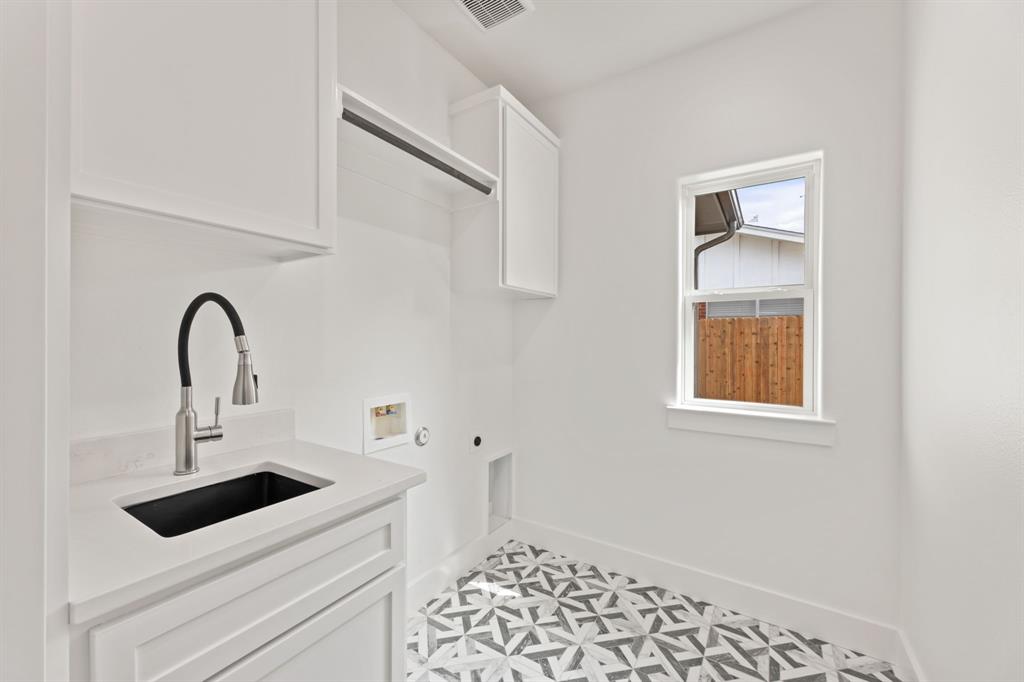 Laundry room with hookup for an electric dryer, hookup for a washing machine, baseboards, a sink, and cabinet space