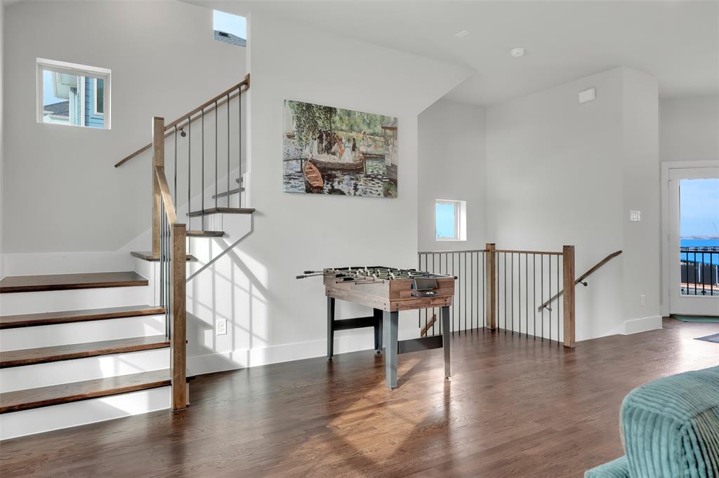 Staircase featuring a high ceiling and wood finished floors Staircase featuring a high ceiling and wood finished floors
