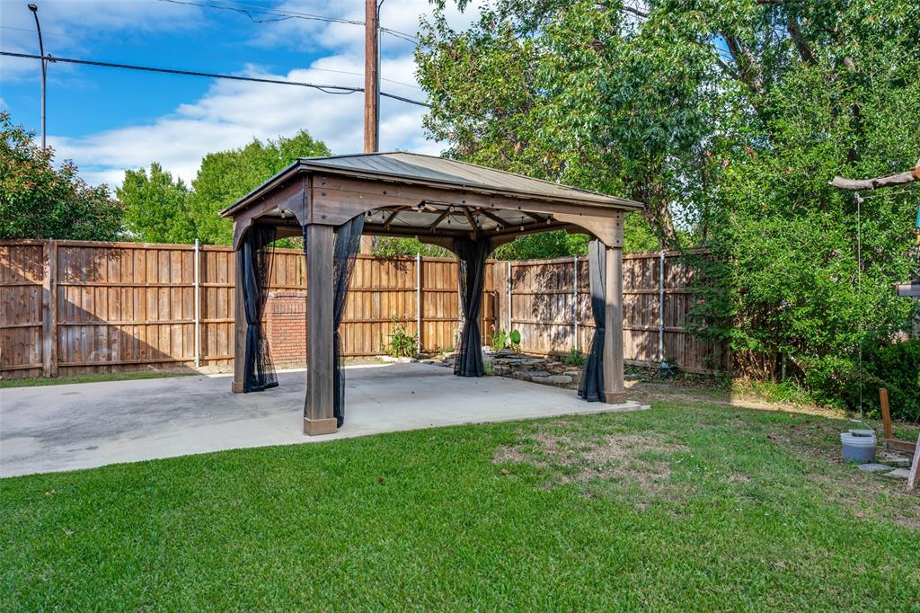 The pergola is attached to the slab in the backyard but is also removable should the owner desire to use this area for parking or other activities. Behind this area is a small pond.
