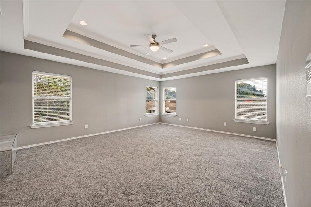 The primary bedroom is well lit from the many windows. Of special interest is the coffered ceiling.