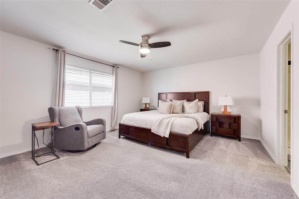 Neutral-toned carpeting, window featuring horizontal blinds, and a ceiling-mounted light fixture with an integrated fan