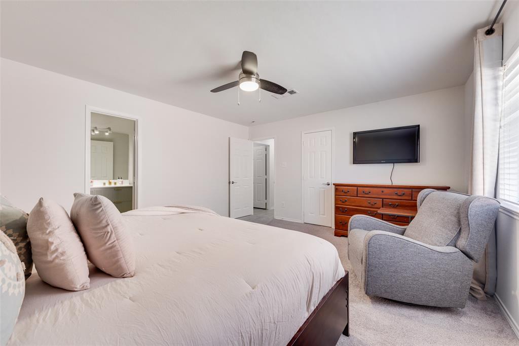 Interior room featuring neutral wall tones, wall-to-wall carpeting, a multi-blade ceiling fan with an integrated light fixture, and two interior doors with paneled detailing