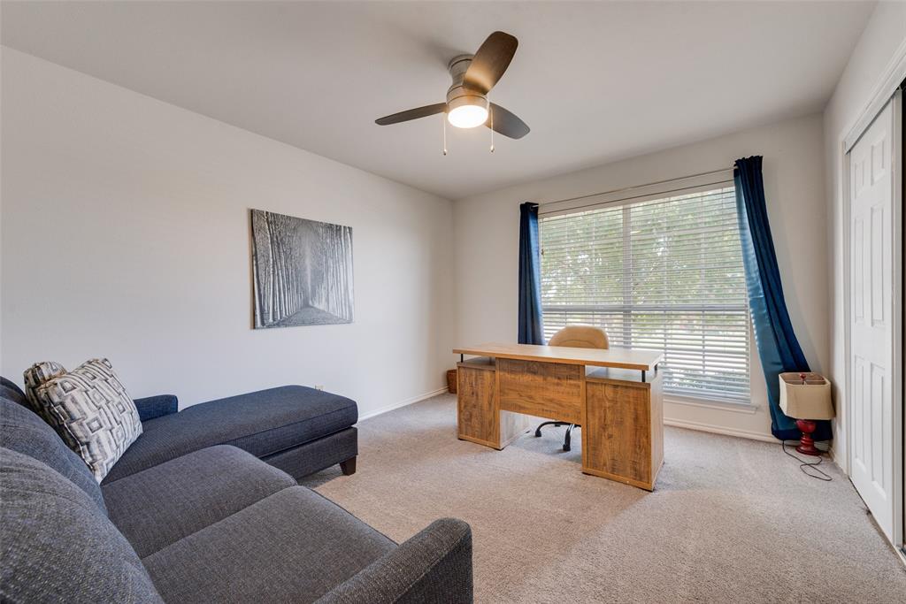 Neutral-toned wall-to-wall carpeting, ceiling fan with integrated lighting, large window with horizontal blinds, and a white paneled closet door