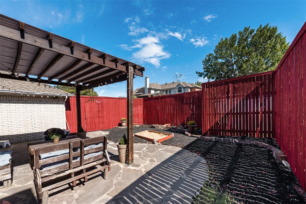 Outdoor living space featuring a wood pergola, flagstone patio, and perimeter wood privacy fencing