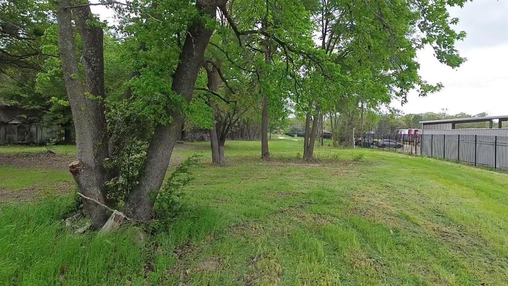 Expansive lot featuring mature trees, natural vegetation, and a metal perimeter fence Expansive lot featuring mature trees, natural vegetation, and a metal perimeter fence