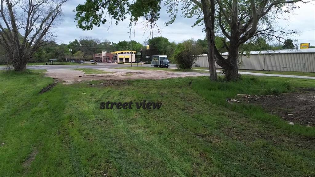 Open-level lot featuring mature trees and direct paved road access