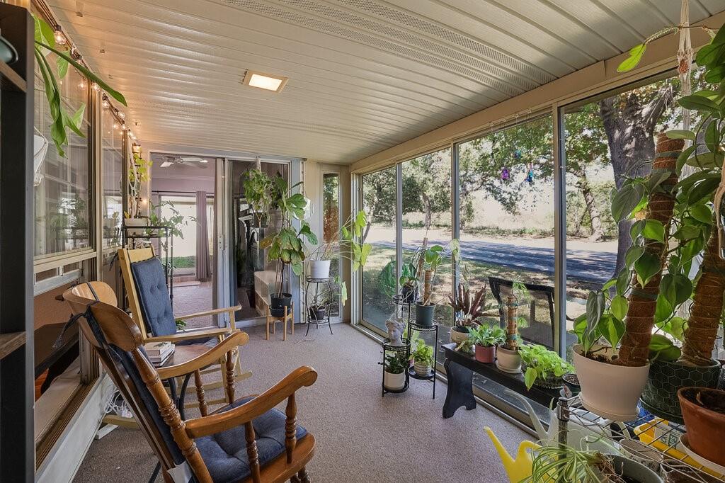 Enclosed sunroom featuring expansive floor-to-ceiling screens, a corrugated ceiling, and wall-to-wall carpeting