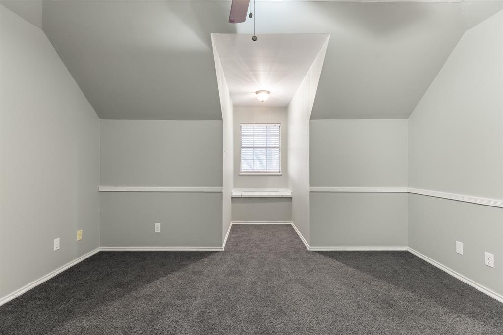 Vaulted ceilings with a ceiling fan, neutral wall paint, chair rail molding, carpeted flooring, and a built-in window seat