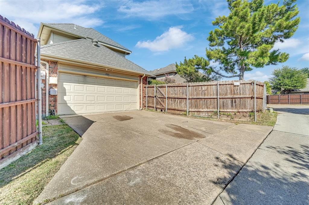 Two-story residence featuring a brick and siding exterior, attached garage, concrete driveway, and wood privacy fencing