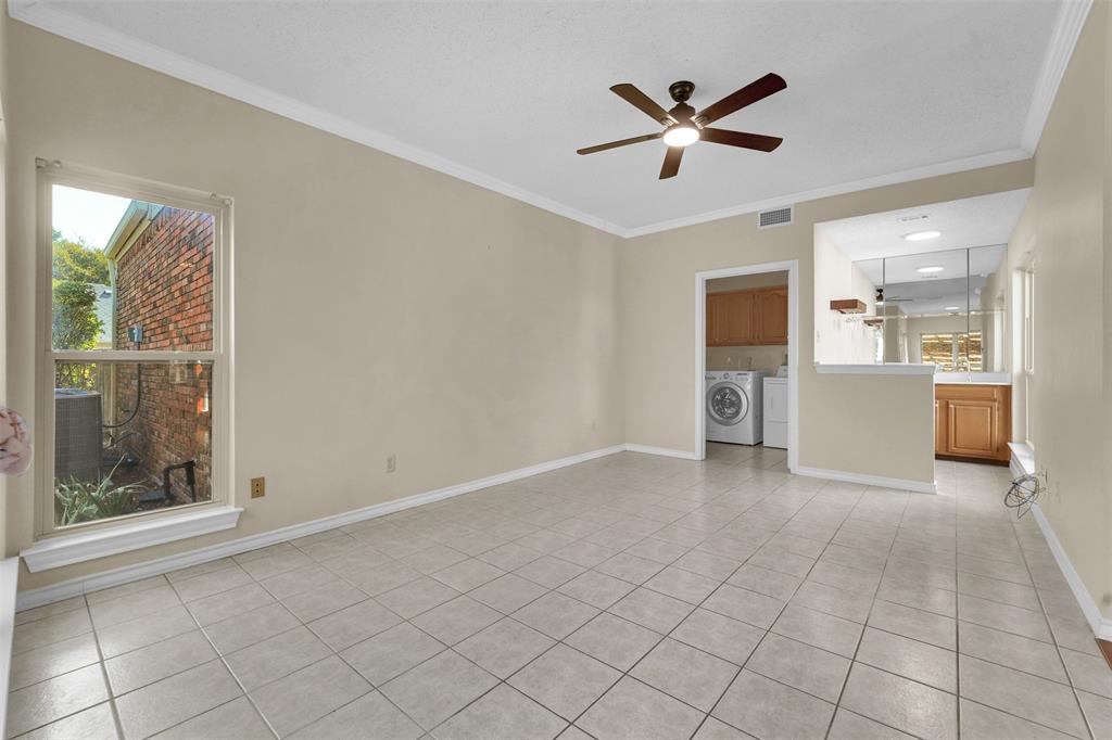 Interior space featuring neutral-tone tile flooring, crown molding, and a central ceiling fan with integrated lighting