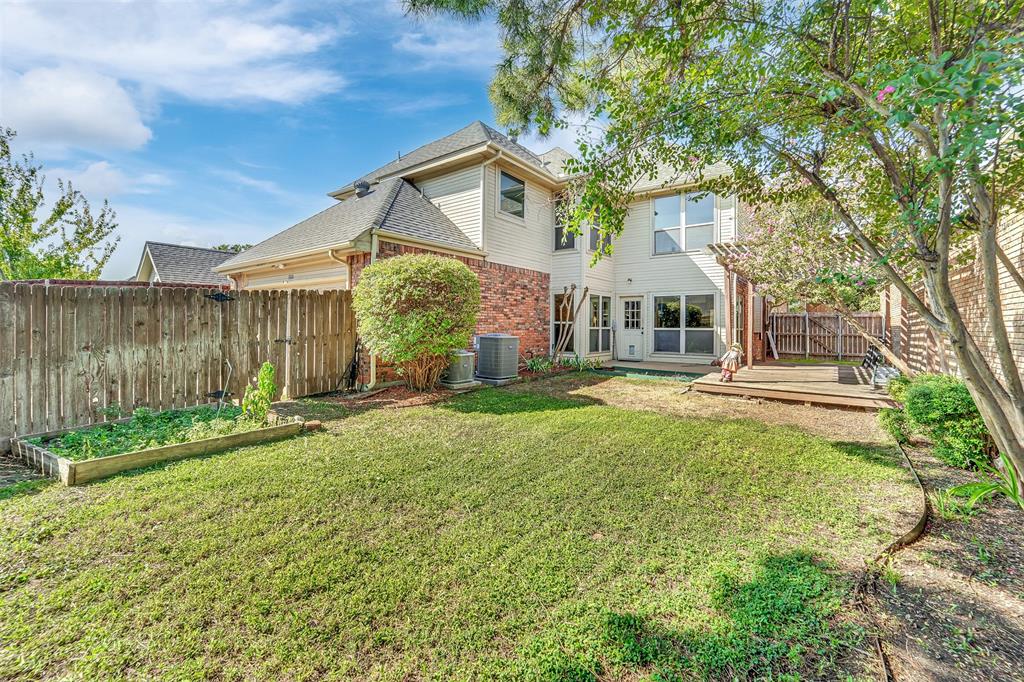 Backyard featuring a wood deck, pergola, raised garden bed, and privacy fencing
