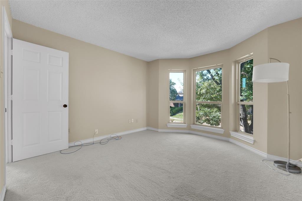 Interior space featuring neutral wall tones, wall-to-wall carpeting, and a bay window assembly