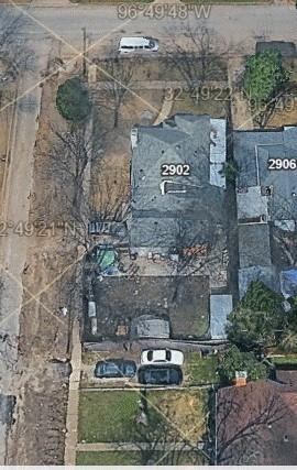 Aerial view of corner lot property featuring mature trees and a detached garage