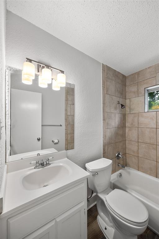 Bathroom featuring a white vanity with integrated sink, chrome faucet, and a four-bulb vanity light fixture