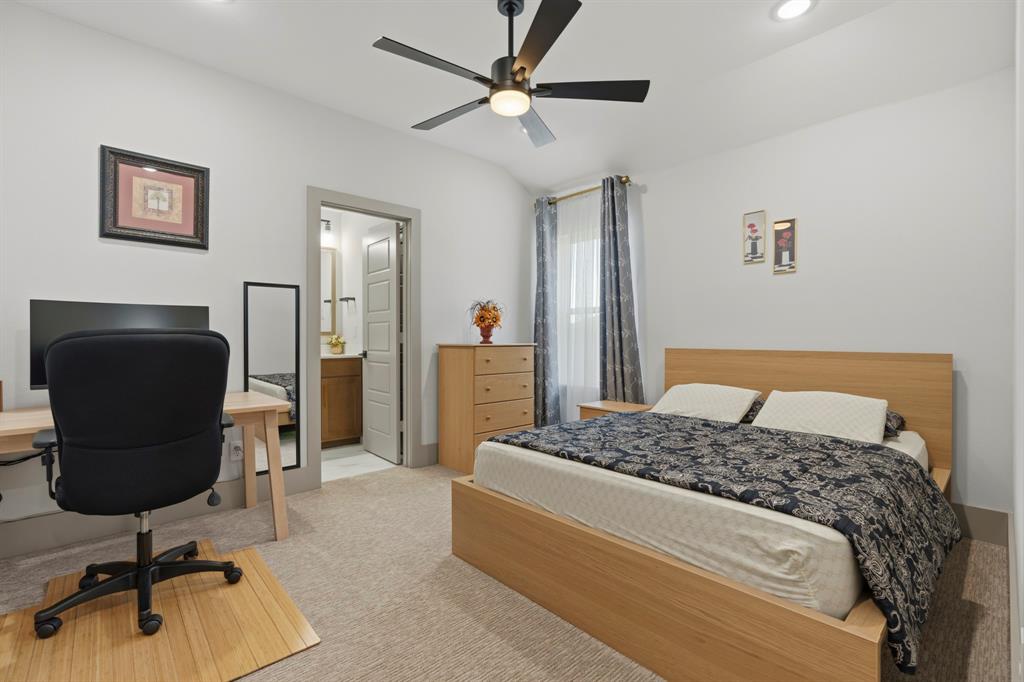 Neutral-toned carpeted room featuring recessed lighting, a ceiling fan with integrated light fixture, and an entry to an interior bathroom