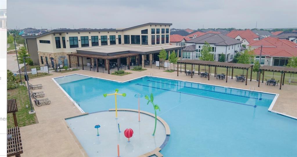 Community recreation facility featuring a swimming pool, an integrated splash pad, and multiple covered pergola structures