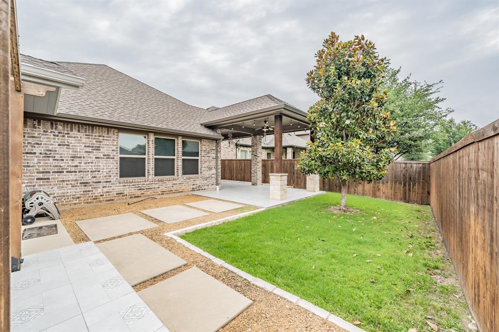 View of yard featuring ceiling fan and a patio