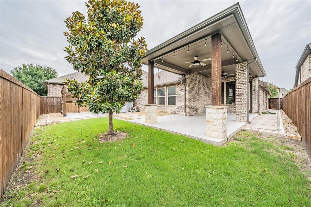 Rear view of property with brick siding, a ceiling fan, and a patio