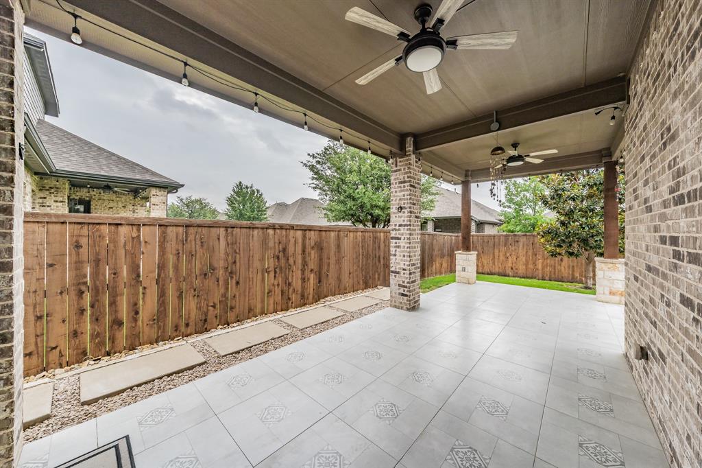 Fenced backyard featuring a ceiling fan and a patio area