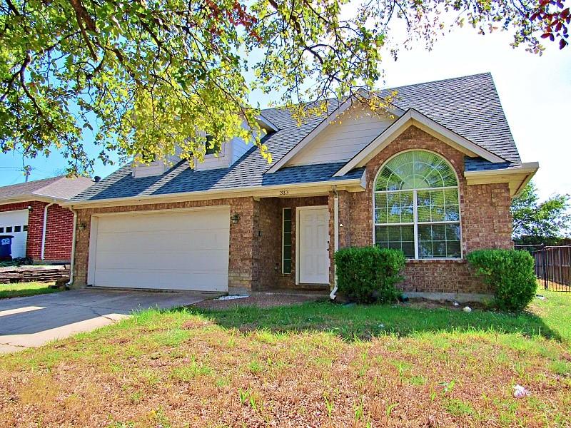 Brick exterior featuring a gabled roofline, arched window, and two-car garage