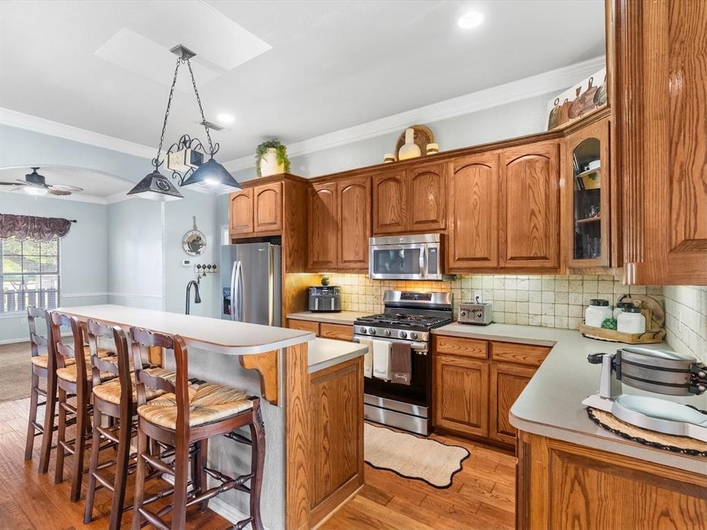 Kitchen has stainless appliances and warm wood cabinets