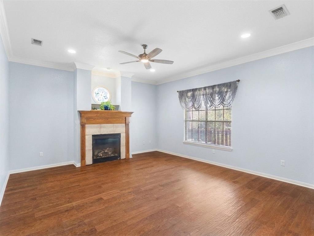 Substantial living room features hardwood floors and inviting fireplace