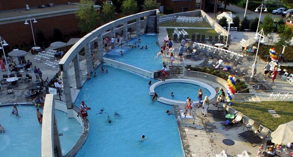 Resort-style aquatic amenity featuring a multi-level swimming pool, a circular spa, and surrounding lounge areas