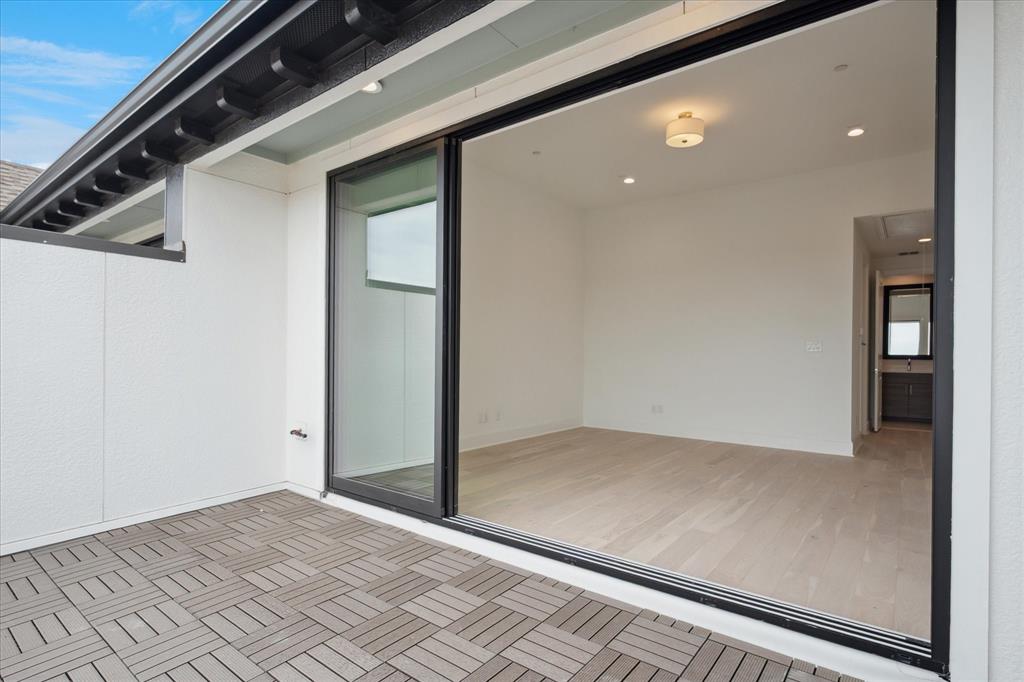 Outdoor patio featuring geometric tile flooring and a black sliding glass door