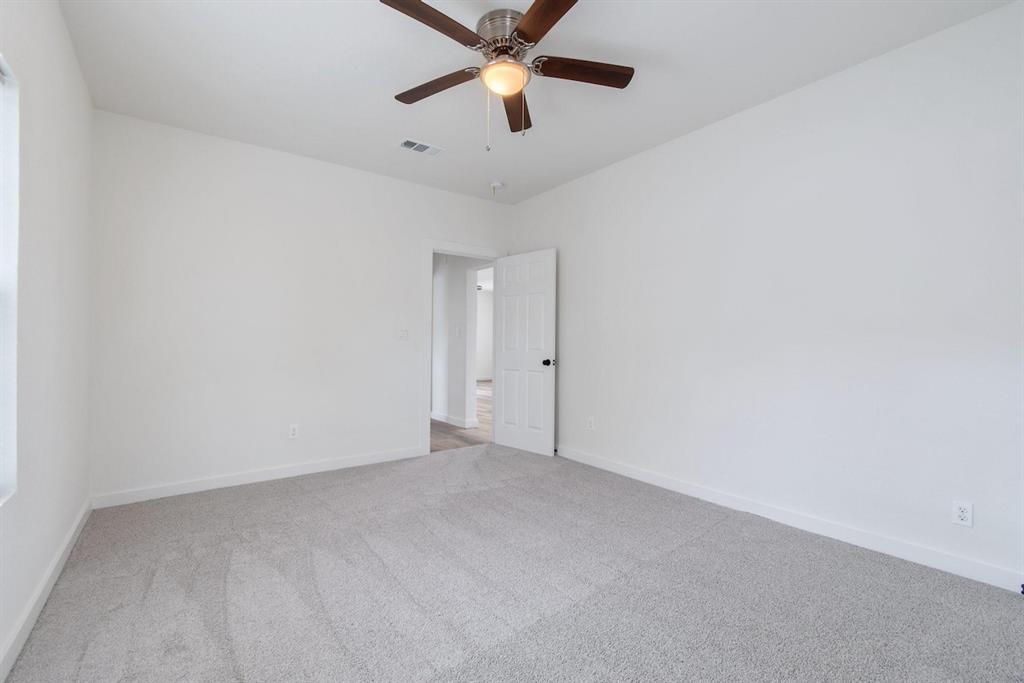 Neutral-toned carpeting, white walls, and a brushed metal ceiling fan with integrated light fixture