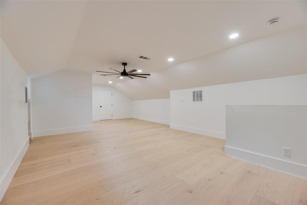 Open-concept area featuring wood-finish flooring, vaulted ceilings, recessed lighting, and a multi-blade ceiling fan