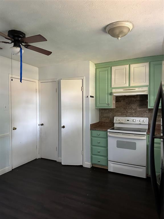 Kitchen featuring wood-finish flooring, two-tone cabinetry, tiled backsplash, and an integrated range hood