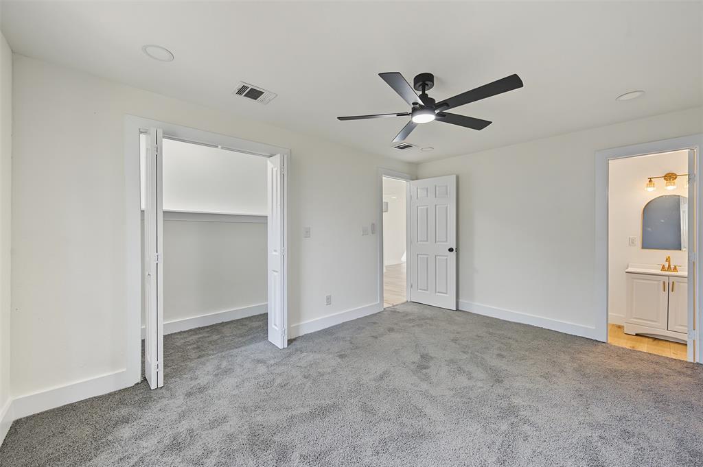 Interior room featuring neutral-toned carpeting, a matte black ceiling fan with integrated lighting, recessed lighting, bi-fold closet doors, and a six-panel interior door