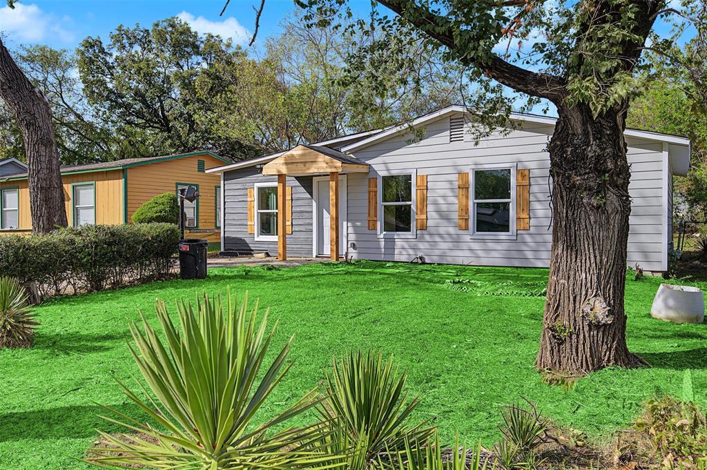 Exterior featuring horizontal siding, decorative wood shutters, a covered front entryway, and established mature trees
