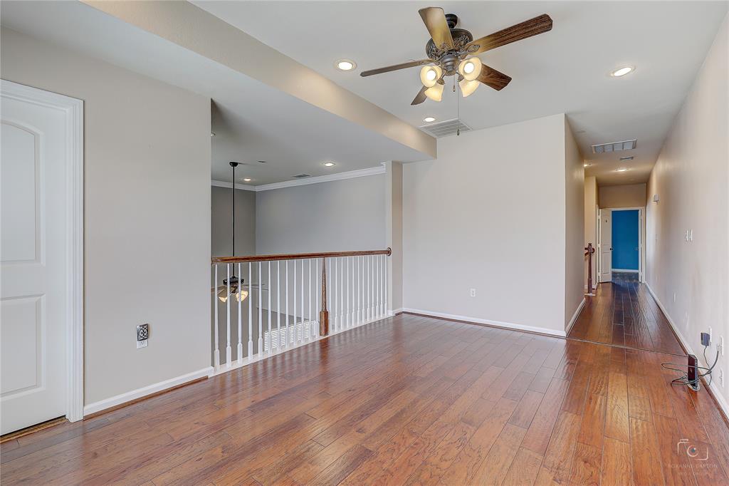 Open floor plan featuring wood-finish flooring, recessed lighting, a ceiling fan with integrated lighting, and a white baluster railing