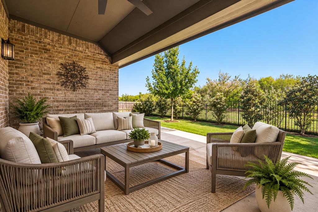 Covered patio featuring brick masonry, a vaulted ceiling, ceiling fan, and concrete flooring