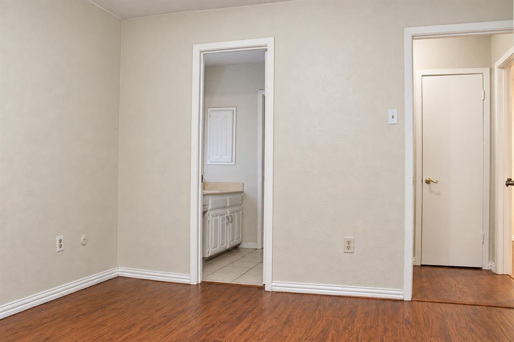 Wood-finish flooring, neutral wall tones, multi-panel interior doors, and custom-finish vanity cabinetry
