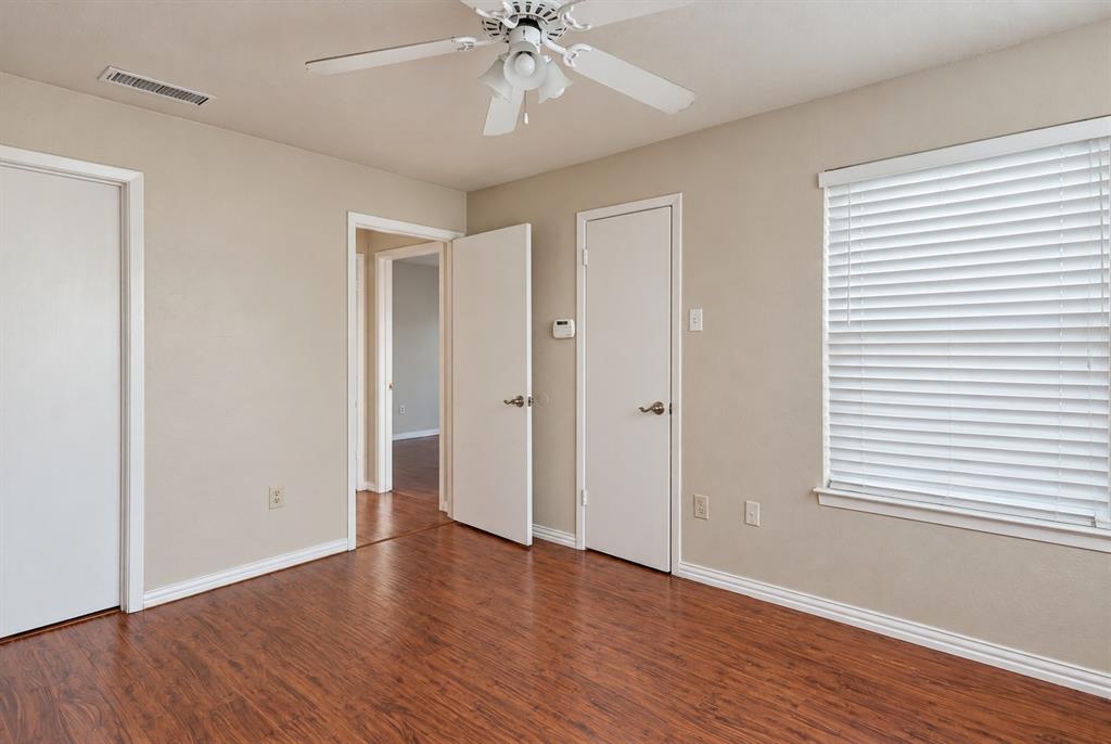 Room featuring wood-finish flooring, a ceiling fan with integrated lighting, and window blinds