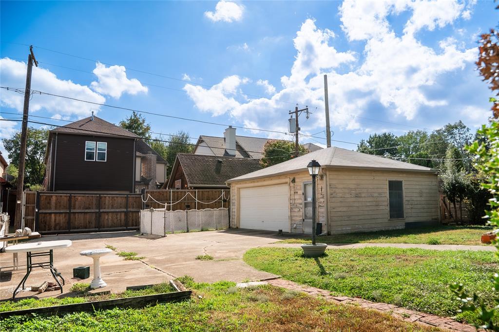 Detached garage with horizontal siding, concrete parking area, and perimeter wood fencing