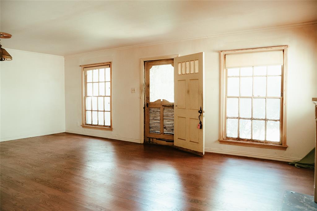 Interior space featuring wood-finish flooring, two multi-pane windows, and a paneled exterior door with inset glass