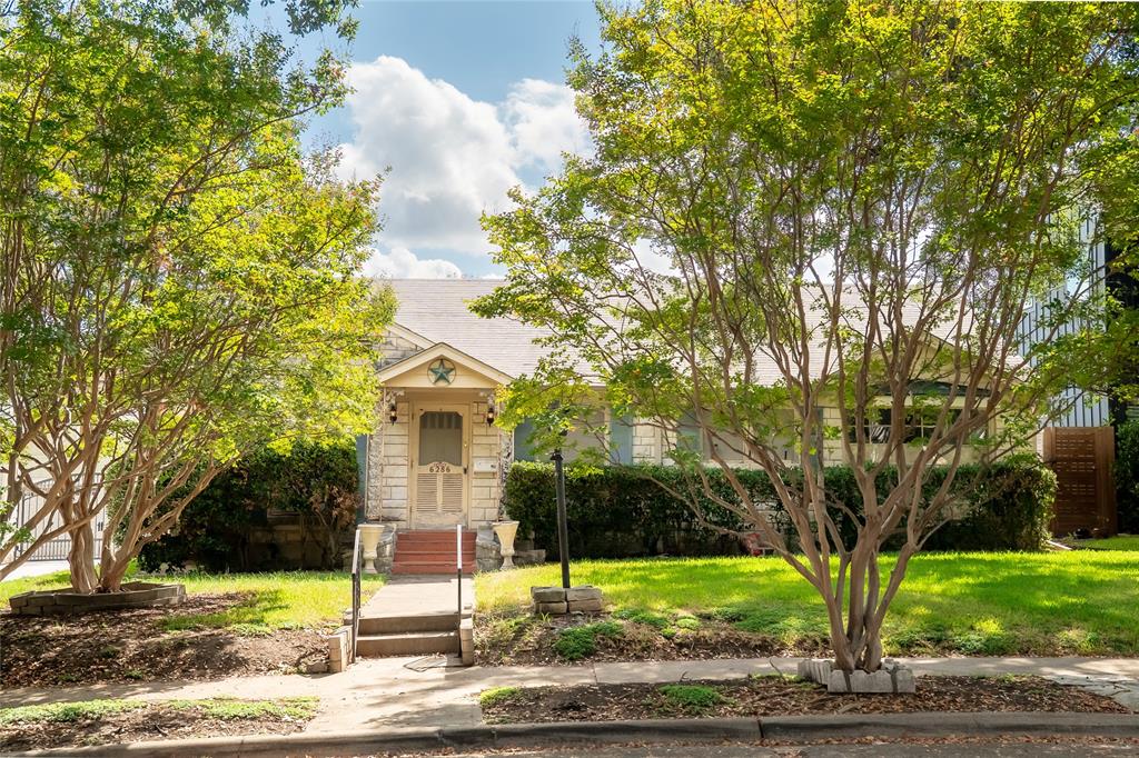 Stone veneer exterior featuring a covered front entryway, concrete walkway, mature landscaping, and an asphalt shingle roof Stone veneer exterior featuring a covered front entryway, concrete walkway, mature landscaping, and an asphalt shingle roof
