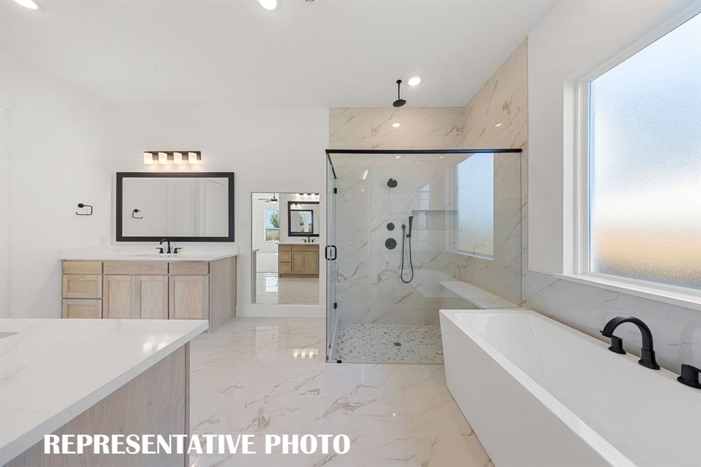 With ample room for two, an oversized walk in shower and freestanding tub, this owner's bath is a dream come true!  REPRESENTATIVE PHOTO