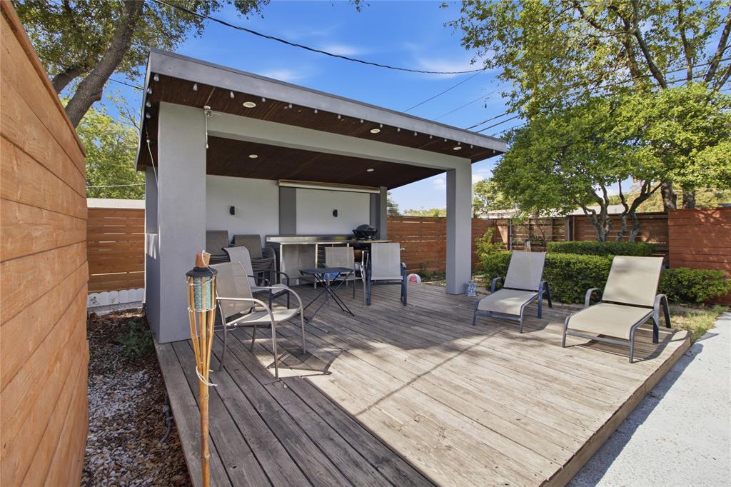 Take outdoor living to the next level with this spacious poolside cabana and expansive wood deck. The covered gathering area features a rich wood-paneled ceiling, recessed lighting, and decorative string lights that help set the mood for evening gatherings. With room for dining, conversation, and poolside lounging, this versatile space is equally suited for intimate get-togethers or lively celebrations. The adjacent open deck provides additional space to enjoy the sunshine just steps from the pool.