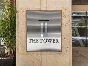 Brushed metal building signage mounted on a textured limestone facade