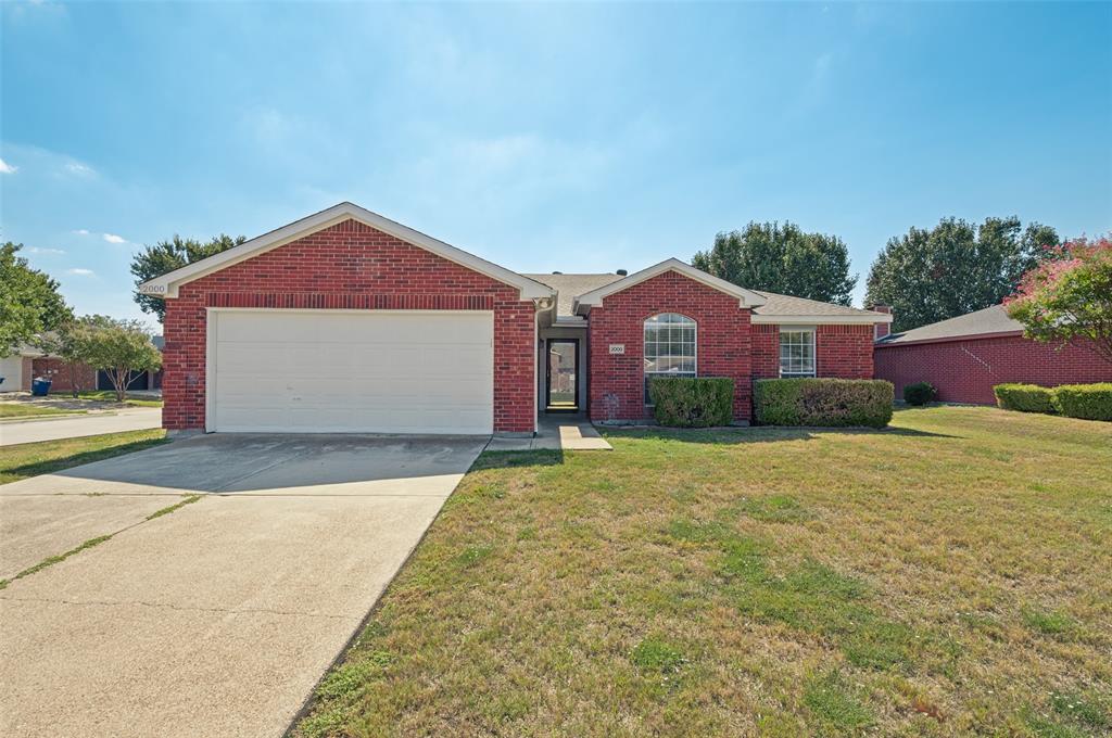Single-story brick exterior featuring a multi-gable roofline, an arched window, and an attached two-car garage