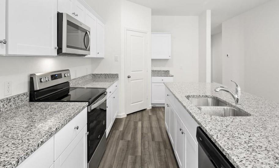 Kitchen featuring white cabinetry, stone-finish countertops, stainless steel appliances, a double-basin undermount sink, and wood-finish flooring
