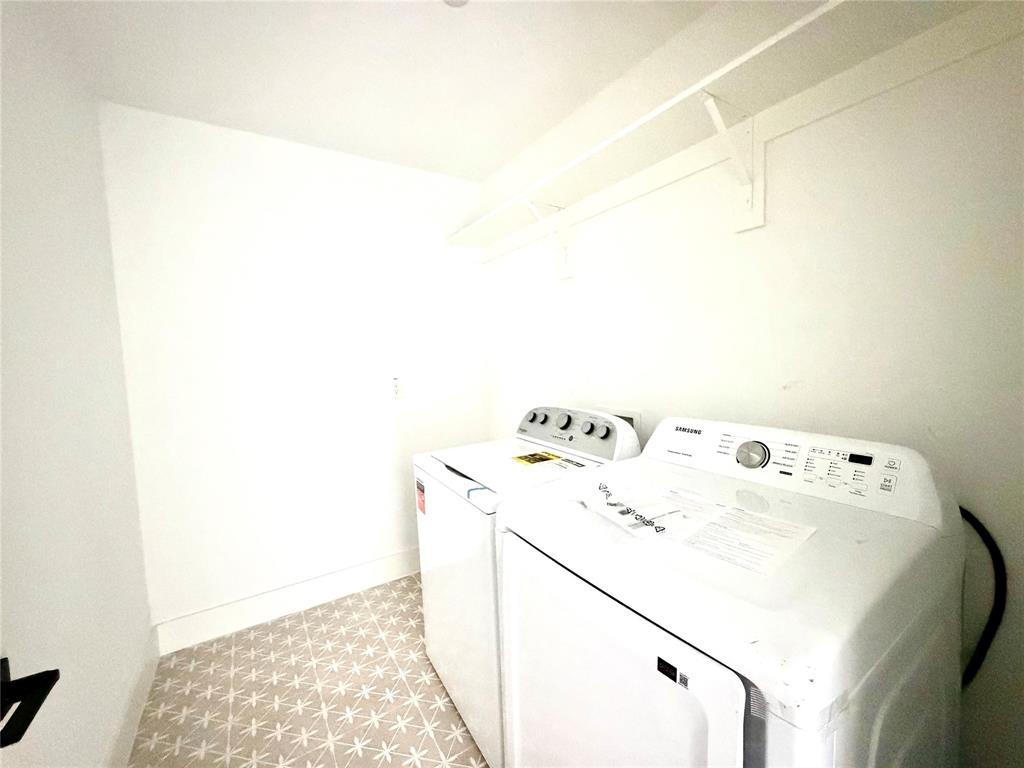 Utility space featuring patterned tile flooring and built-in white overhead shelving with a mounted hanging rod