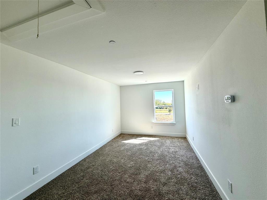 Neutral-toned wall paint, wall-to-wall carpeting, and a single-pane window