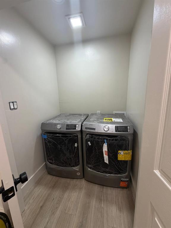 Laundry alcove featuring wood-finish flooring and recessed ceiling lighting