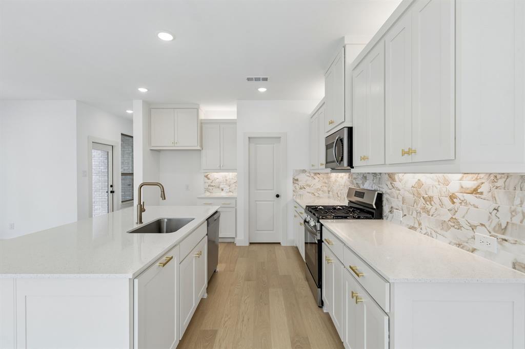 Beautiful cabinetry, gorgeous counter tops and striking backsplash effortlessly pair with contemporary stainless steel to create a kitchen for the ages!  REPRESENTATIVE PHOTO