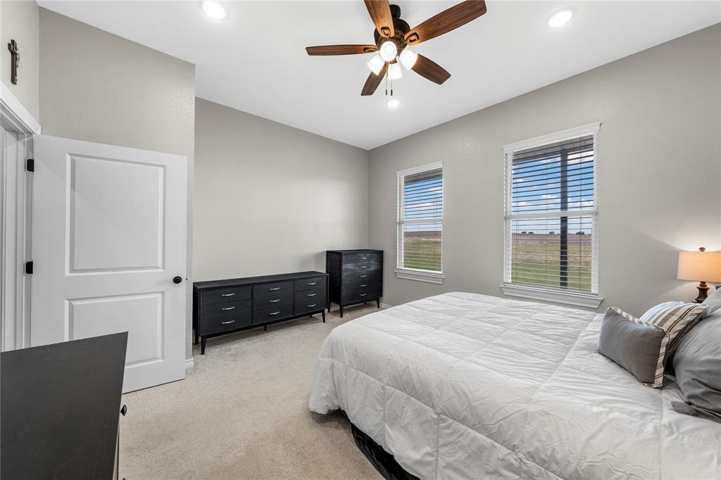 Room featuring neutral wall paint, carpeted flooring, recessed lighting, a ceiling fan with integrated lighting, and two windows with horizontal blinds